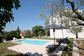 A swimming pool with chairs and umbrellas around it
