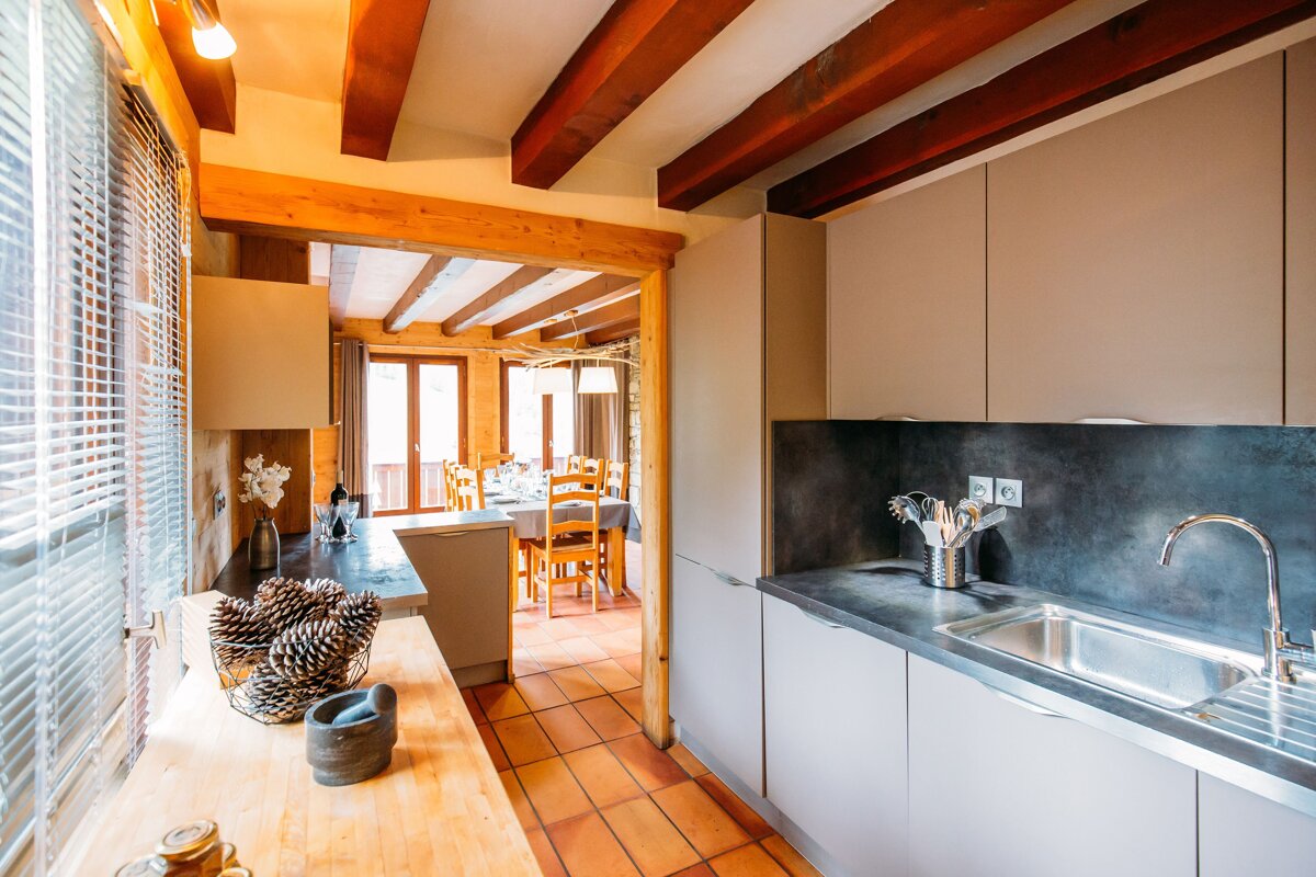 A kitchen with a sink and a bowl of pine cones on the counter
