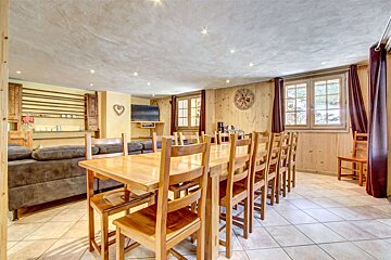 A dining room with a long table and chairs