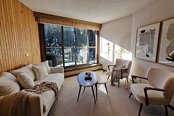 A living room with a couch and two chairs