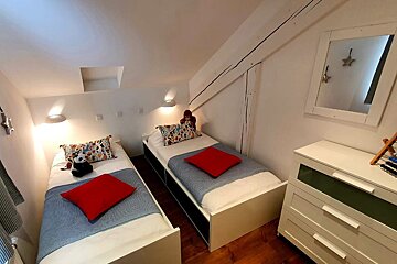 A bedroom with two twin beds and a dresser