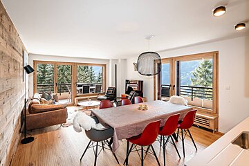A living room with a dining table and chairs