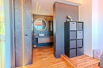 A bathroom with a sink and a round mirror