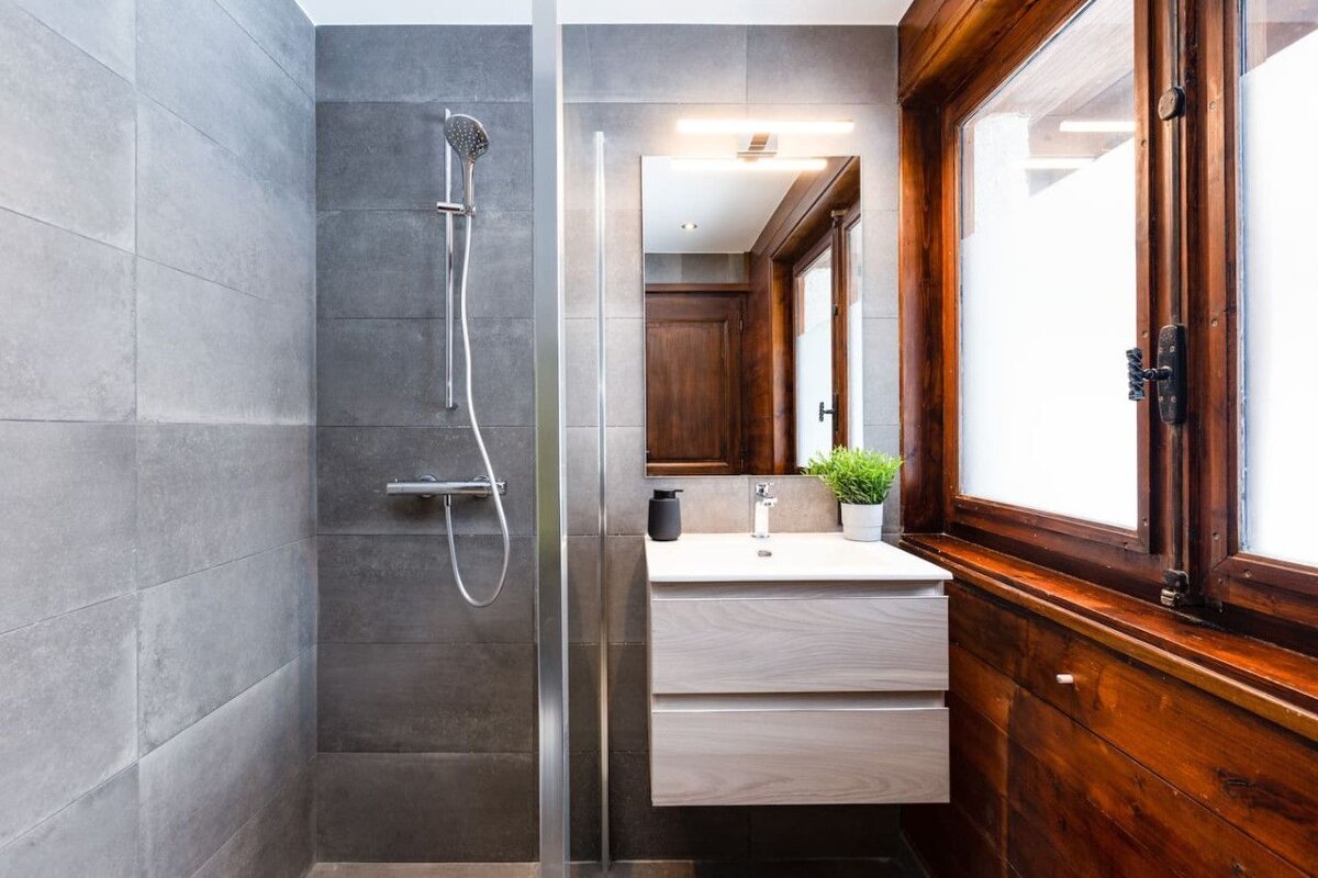 A bathroom with a sink and a walk in shower