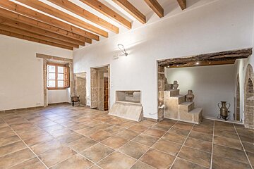 A room with tile floors and wooden beams on the ceiling