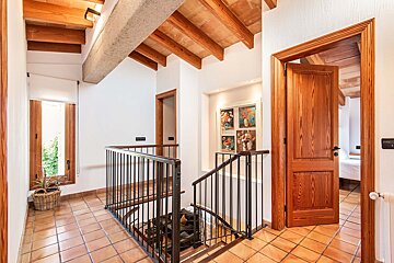 A hallway with a staircase leading up to the second floor