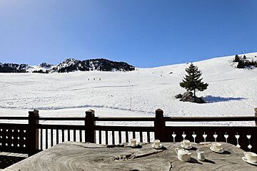 A wooden table with a view of a snowy mountain