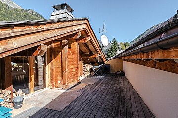 A wooden deck with a satellite dish on the roof