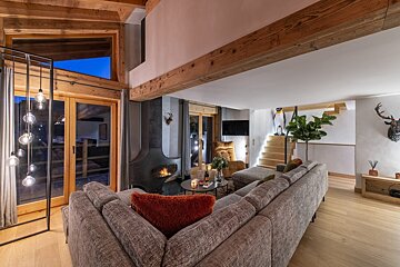 A living room with a large sectional couch and a fireplace