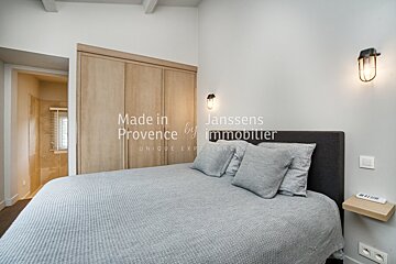 A bedroom with a bed and a sign that says made in provence
