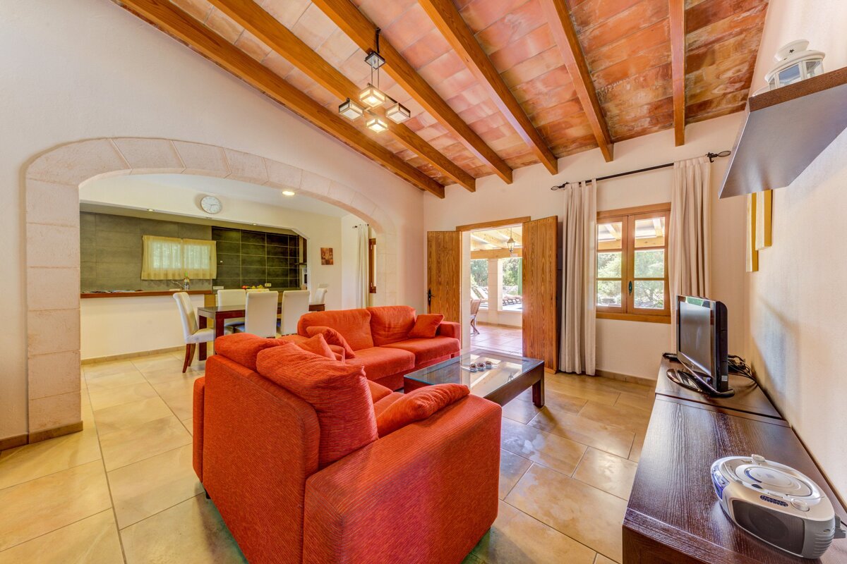 A living room with two red couches and a television