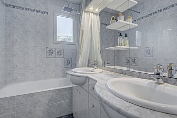 A bathroom with a sink a bathtub and a mirror