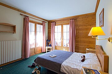 A hotel room with a bed and a book on the bed