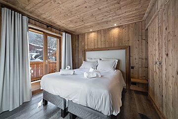 A balcony overlooking a snowy landscape with mountains in the background