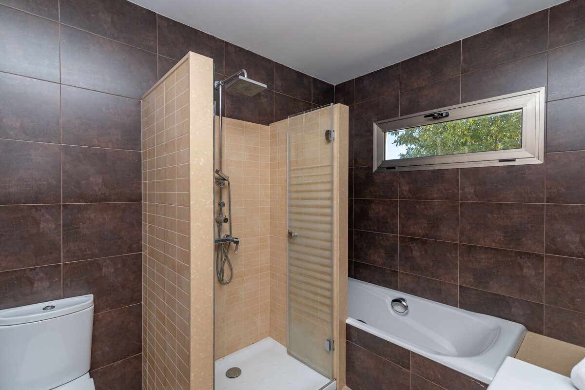 A bathroom with a tub and a shower with a glass door