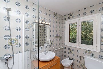 A bathroom with blue and yellow tiles and a sink
