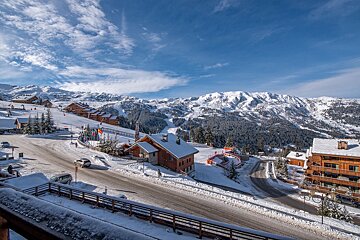 A snowy mountain landscape with a few houses in the foreground