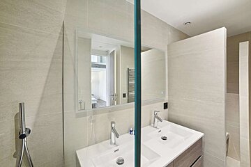 A bathroom with two sinks and a large mirror