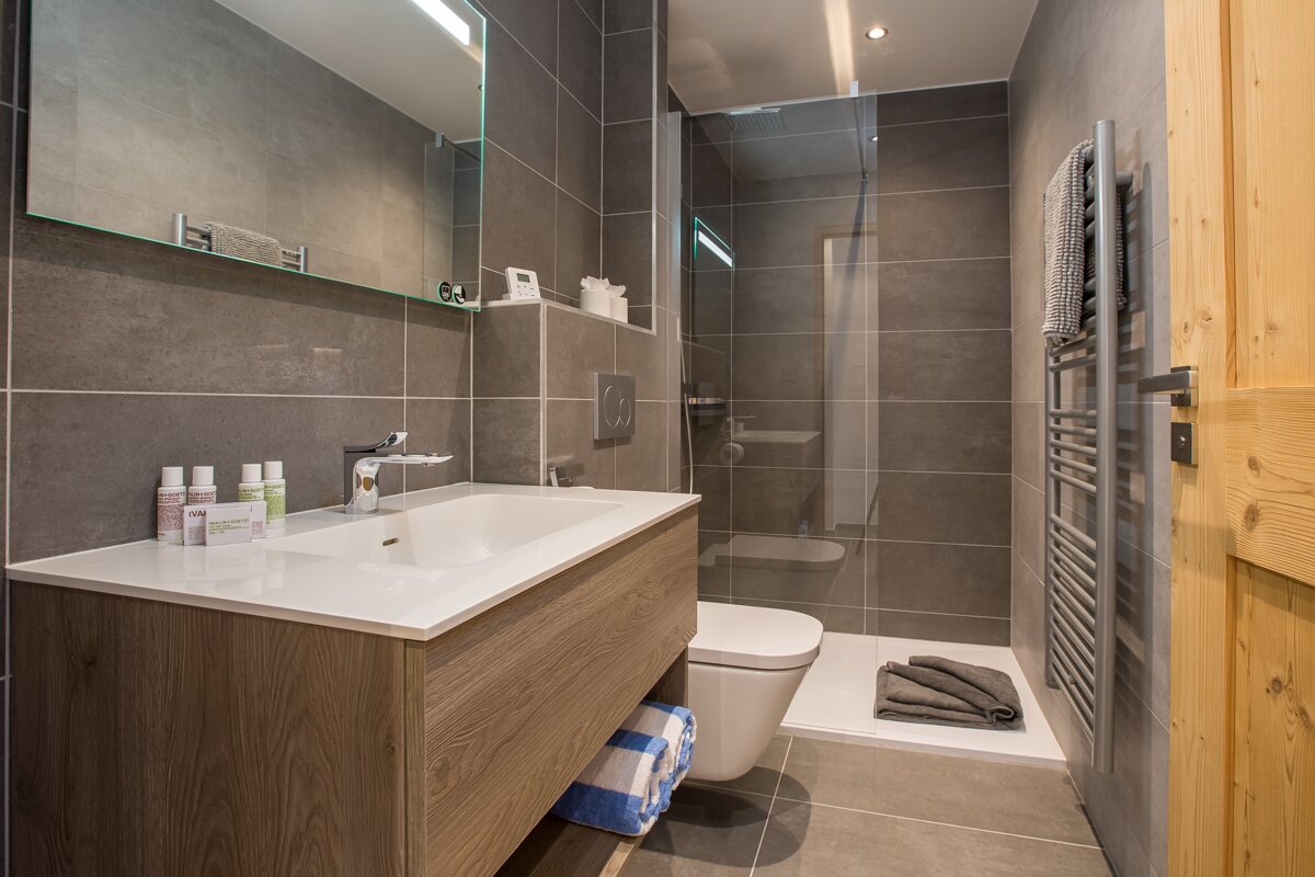 A bathroom with a toilet a sink and a mirror