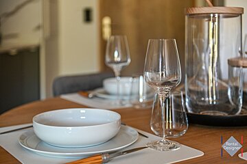 A table set with plates bowls and wine glasses by rental designs