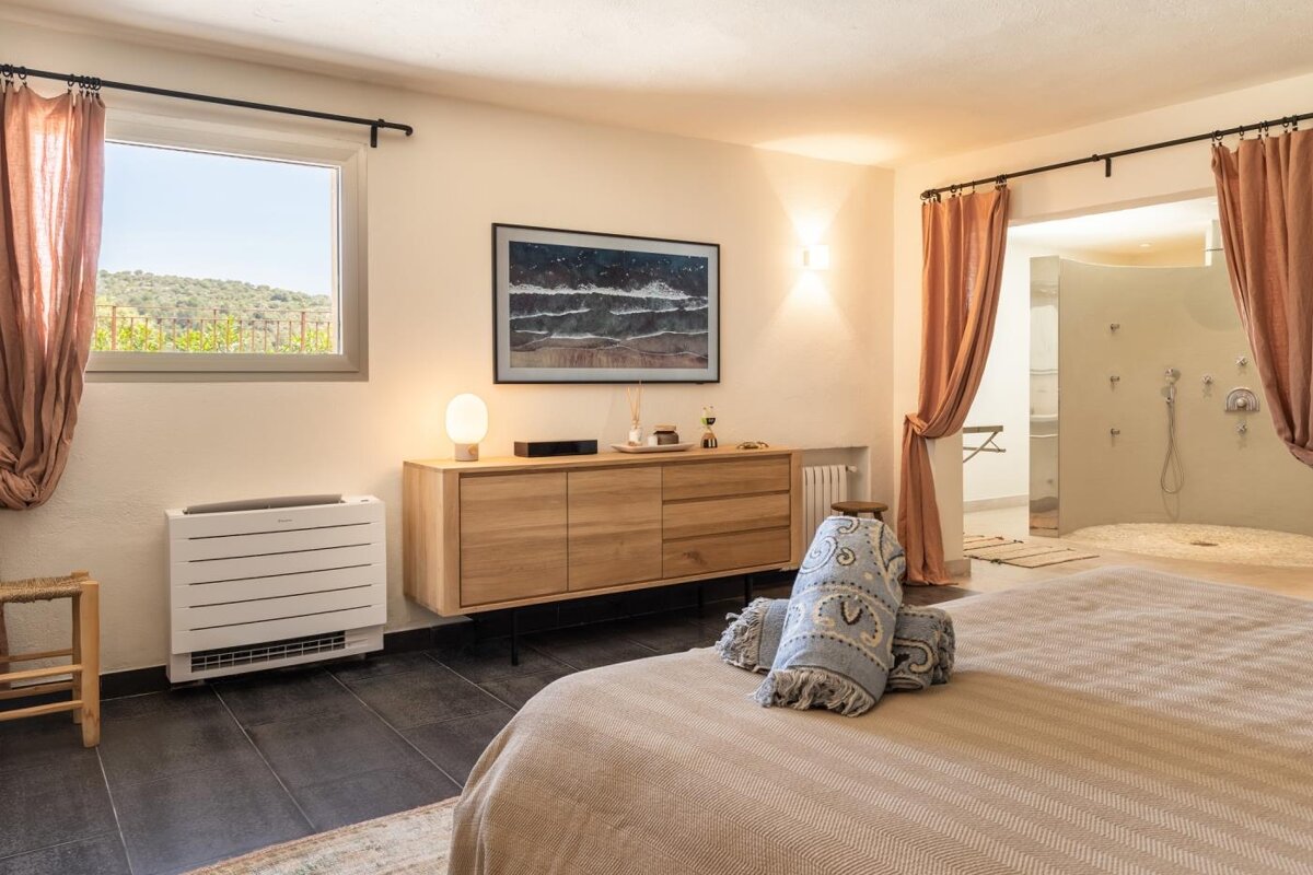 A bedroom with a large picture on the wall above the bed