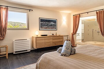 A bedroom with a large picture on the wall above the bed