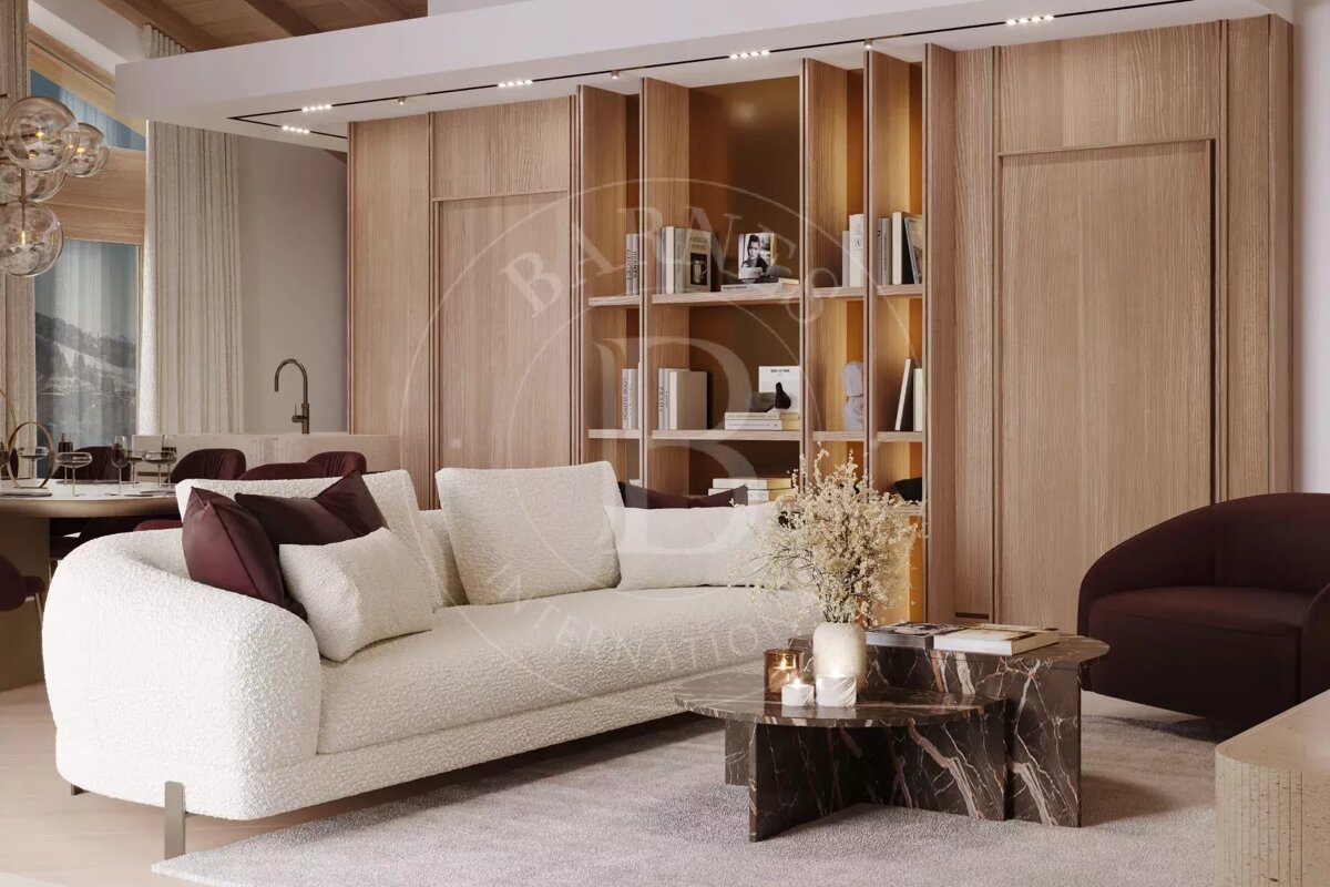 A modern living space with a white bouclé sofa, dark marble coffee table, light wood shelves, and a window revealing mountain views.