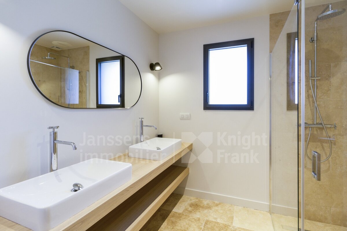 A bathroom with two sinks and a knight frank logo