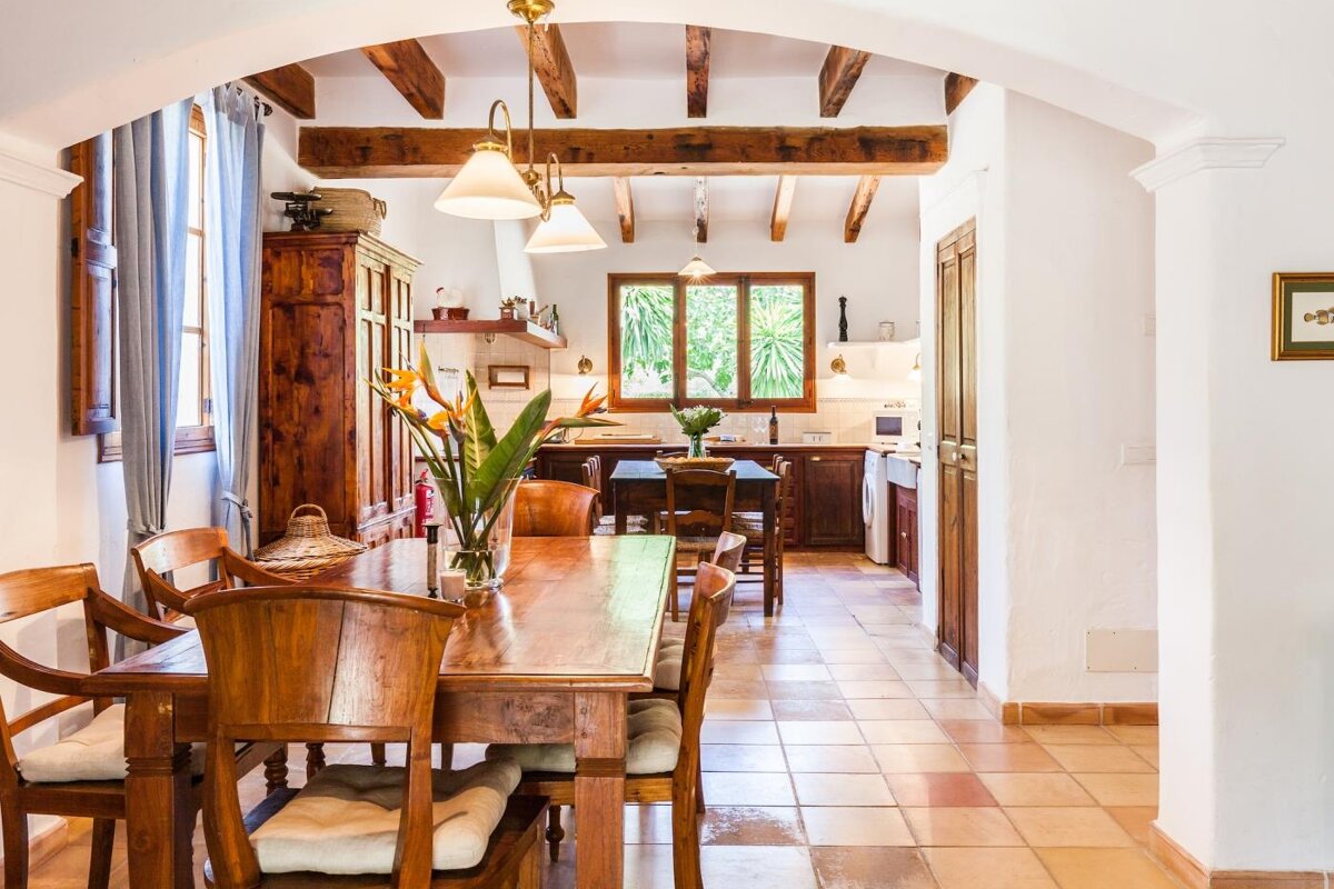 A dining room table with a vase of flowers on it