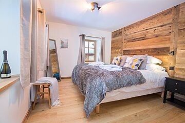 A bedroom with a bed and a bottle of champagne