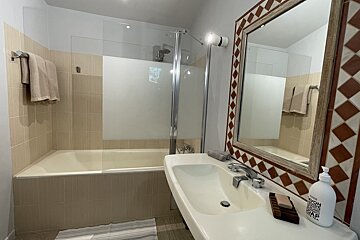A bathroom with a sink and a bottle of soap