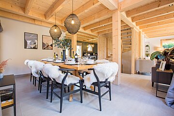 A dining room with a wooden table and chairs