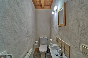 A bathroom with a toilet a sink and a mirror