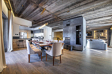 A dining room with a wooden table and chairs