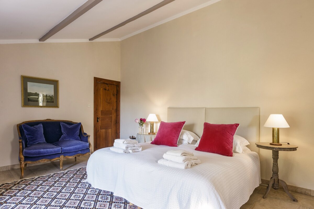 A bedroom with a large bed and a blue couch