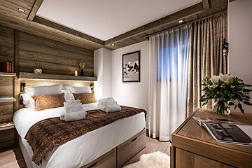 A bedroom with a bed and a vase of flowers