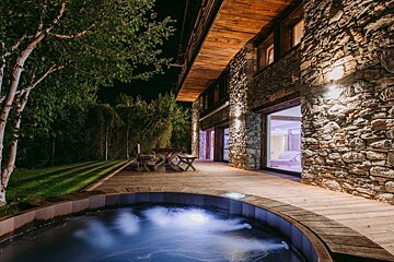 A large stone building with a hot tub in front of it
