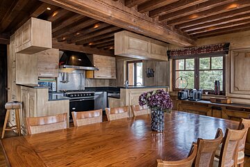 A kitchen with a table and chairs and a vase of flowers