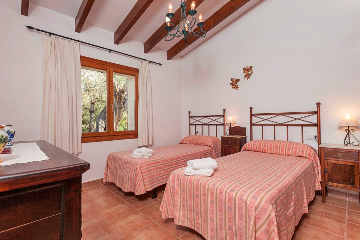 A bedroom with two twin beds and a chandelier