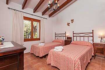 A bedroom with two twin beds and a chandelier