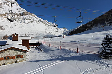 A ski lift is going up a snowy mountain