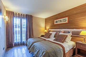A bedroom with brown curtains and a bed with a fur blanket