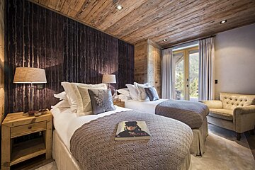 A bedroom with two beds and a book on the bed that says chanel