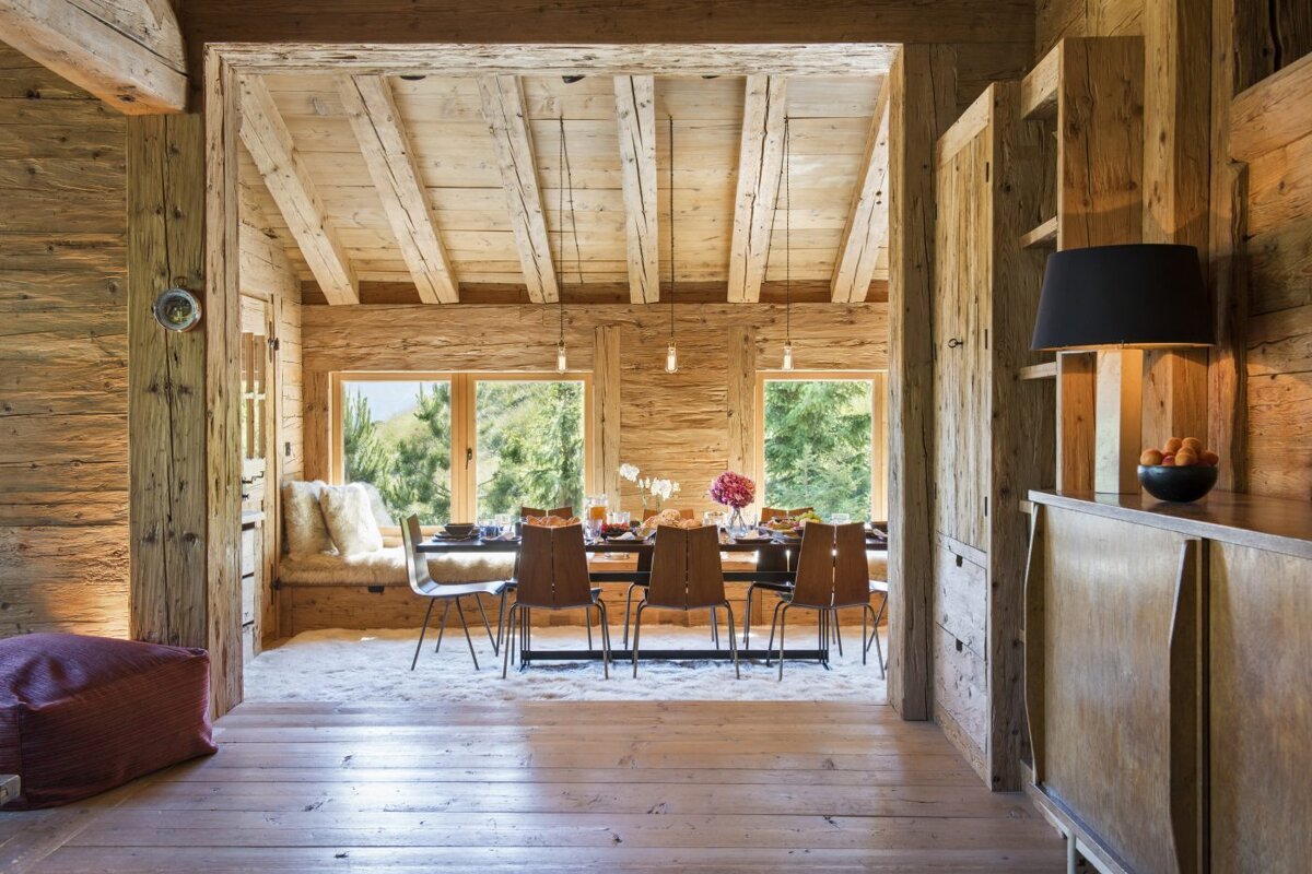 A wooden dining room with a table and chairs
