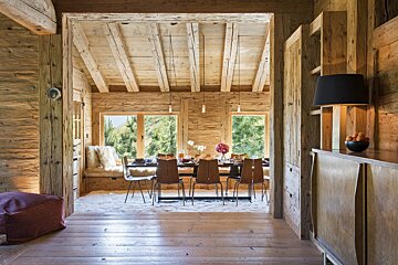 A wooden dining room with a table and chairs
