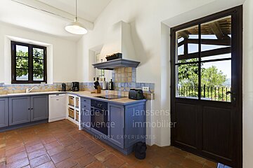 A kitchen with blue cabinets and a door that says janssens immobilier