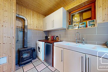 A kitchen with a washing machine and a sink with alpine-pro written on the bottom