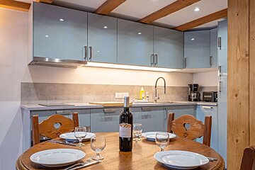 A bottle of wine sits on a table in a kitchen