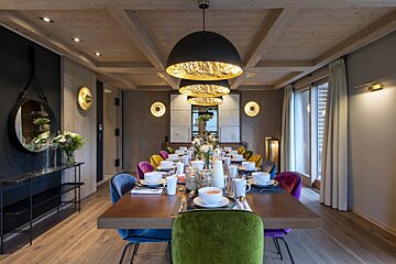 A dining room with a long table and chairs