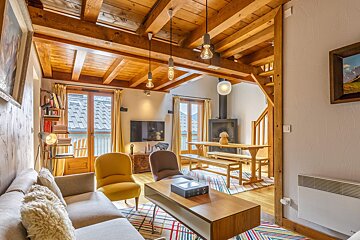 A living room with a couch and chairs and a book on the coffee table